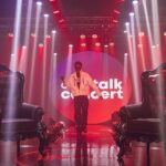 a man standing on a stage in front of chairs